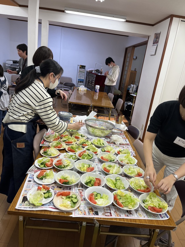 古口直美さんの この一枚「岡山教会の教会学校と合同で、ハレルヤチャーチキャンプ(お泊まりもあり)の1日目の夕食作りです。大人がやってるのは盛り付けで、材料を切ったのは子どもたちです。」